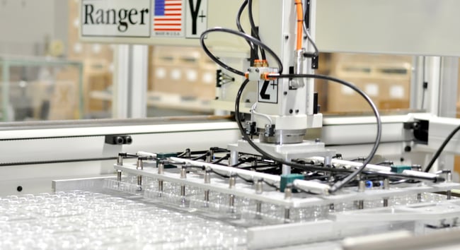 robot strips thermoformed tray after manufacturing and die cutting